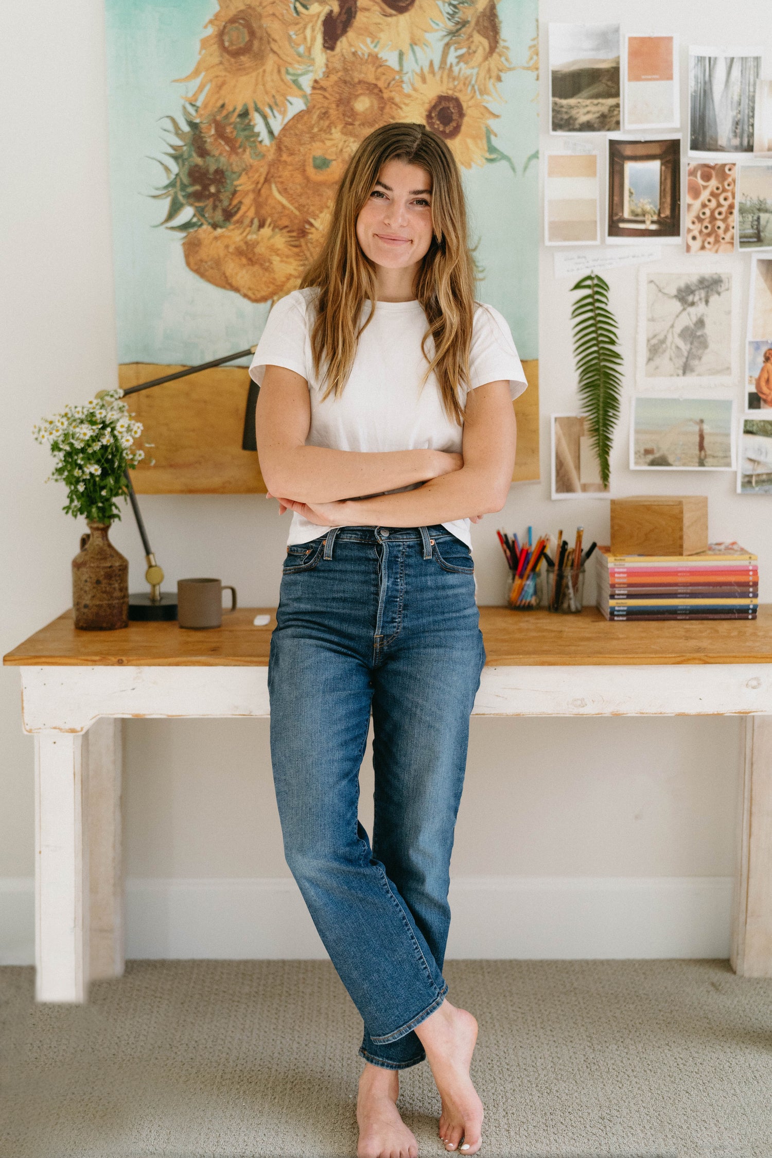 Founder of The Paper Way, Sally Crowther, in her studio with vintage art, paper swatches, and pressed botanical inspiration.